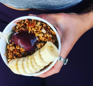 Hannah holding an Acai Sorbet topped with an aspired sesame granola from the North Shore, Oahu